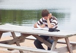 Sam enjoys studying the Word by the lake
