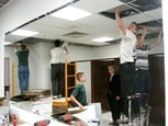Putting ceiling tiles up in one of the new restrooms.